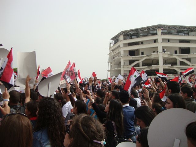 Pro-Asad Demostration. Foto Sammy.aw (نقاش) 17:31، 23 مايو 2011 (ت ع م) - Lizenziert unter CC BY-SA 2.5 via Wikimedia Commons.