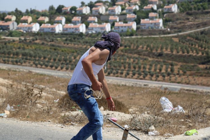 Ein palästinensischer Jugendlicher aus dem Dorf Nabi Saleh macht sich bereit Steine auf IDF-Soldaten zu schleudern. 28. August 2015. Foto Eric Cortellessa / Times of Israel
