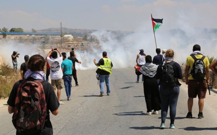 Demonstranten und Medienvertreter starten aus dem Dorf Nabi Saleh, und bewerfen IDF-Soldaten mit Steinen. Diese antworten mit Tränengas. 28. August 2015. Foto Eric Cortellessa / Times of Israel
