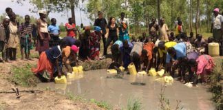 Sivan Ya'ari mit Bukadukha Dorfbewohnern in Uganda sammelt schmutziges Wasser aus den alten Wasserquellen. Foto Innovation: Africa