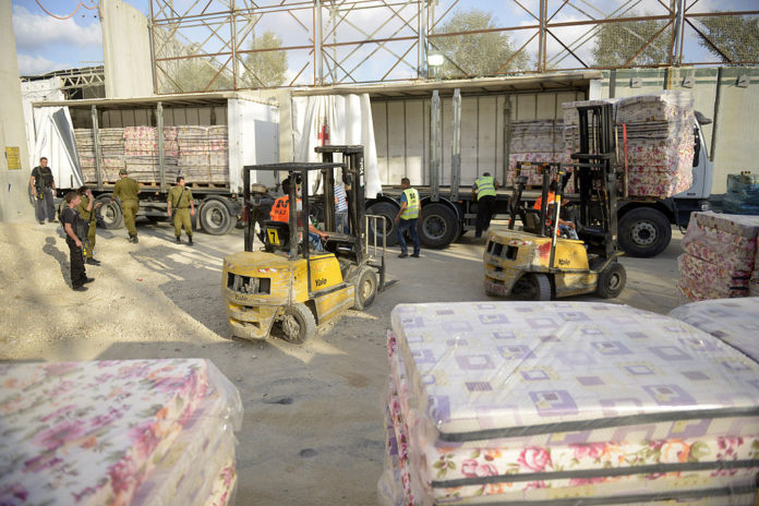 Rund 100 Tonnen Ausrüstung und Waren werden nach Gaza über den Kerem Shalom Übergang verfrachtet, 19. Juli 2014. Foto Israel Defense Forces, CC BY-SA 2.0, https://commons.wikimedia.org/w/index.php?curid=34358141