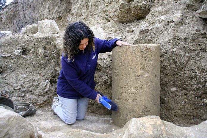 Danit Levy, Leiterin der Ausgrabungen im Auftrag der Israel Antiquities Authority (IAA), neben dem Stein mit der Inschrift. Foto Yoli Shwartz, IAA