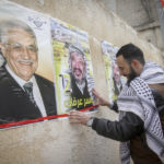 Palästinenser hängen Poster, die den verstorbenen palästinensischen Führer Yasser Arafat und den palästinensischen Präsidenten Mahmoud Abbas in der Stadt Nablus im Westjordanland zeigen. Foto Nasser Ishtayeh/Flash90