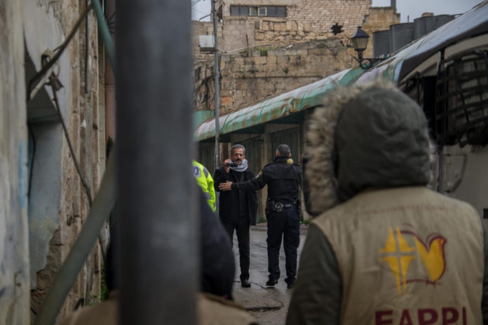 EAPPI-Aktivisten in der Stadt Hebron mit einem Fotografen von B'Tselem. 28. Januar 2019. Foto Dan Raubenehimer/TPS