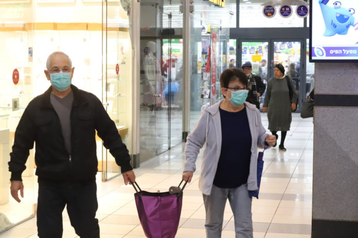 Menschen im Mega-Supermarkt in Qiryat Ono tragen Masken, um sich vor dem Coronavirus zu schützen. Foto Eitan Elhadez/TPS