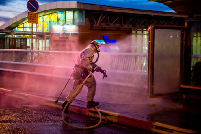 Feuerwehrleute der israelischen Feuerwehr- und Rettungsbehörde in Schutzanzügen desinfizieren öffentliche Bereiche in der Stadt Rishon Leziyyon am 15. März 2020. Foto Kobi Richter/TPS