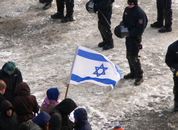 Zeigen einer Israelflagge bei einer Demonstration, 2013. Foto Fatelessfear, CC BY-SA 3.0, https://commons.wikimedia.org/w/index.php?curid=27467260