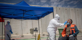 Medizinisches Personal von Magen David Adom bei einer Drive-Through-Stelle zur Entnahme von Proben für Coronavirus-Tests im Shuafat-Flüchtlingslager in Ost-Jerusalem, 16. April 2020. Foto Yonatan Sindel/Flash90