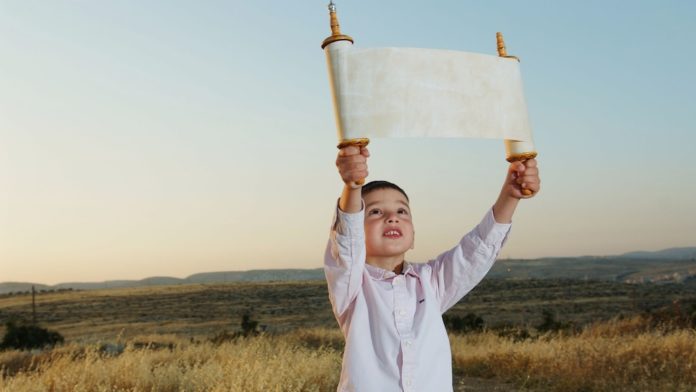 Ein kleiner jüdischer Junge hält eine Thorarolle, vor dem jüdischen Feiertag Schawuot. Foto Flash90