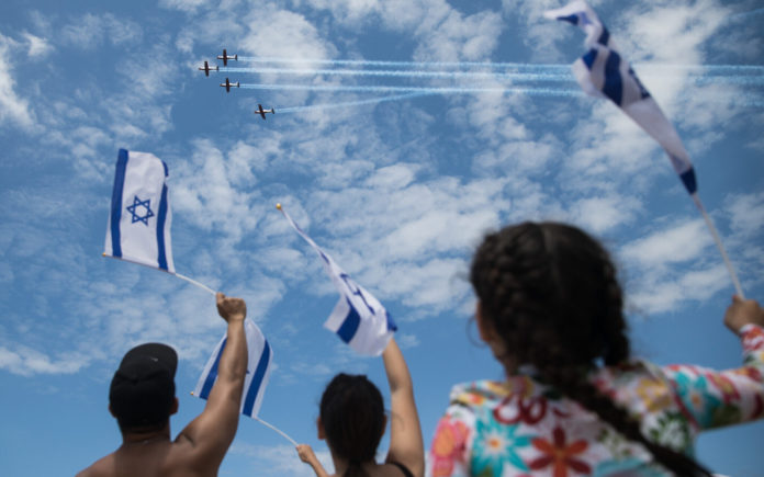 Menschen am Bograschow-Strand in Tel Aviv verfolgen die Militärflugvorführung zum 71. Unabhängigkeitstag Israels am 9. Mai 2019. Foto Hadas Parush/Flash90