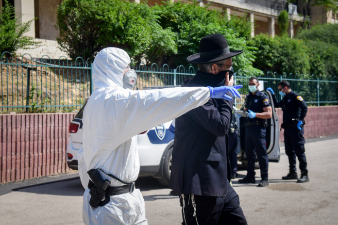 Les policiers israéliens retirent les hommes ultra-orthodoxes de la yeshiva de Ponevezh à Bnei Brak, dans le cadre d'un effort pour imposer un verrouillage afin d'empêcher la propagation du coronavirus le 2 avril 2020. Foto Flash90