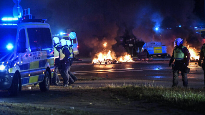 Bereitschaftspolizei und Rauch aus brennenden Reifen und Paletten sowie Feuerwerkskörper, als einige hundert Demonstranten am 28. August 2020 im Stadtteil Rosengard in Malmö, Schweden, randalieren. Foto imago images / TT
