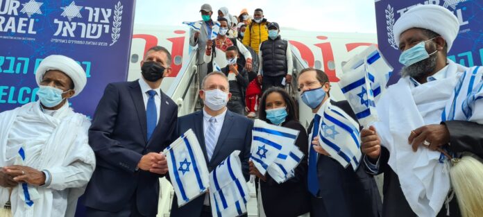 Unter anderem der Vorsitzende der Jewish Agency, Isaac Herzog (Mitte rechts), und die Ministerin für Aliyah und Integration, Pnina Tamano-Shata (Mitte), begrüssen am 11. März 2021 neue äthiopische Einwanderer am Flughafen Ben Gurion. Foto The Jewish Agency/GPO.