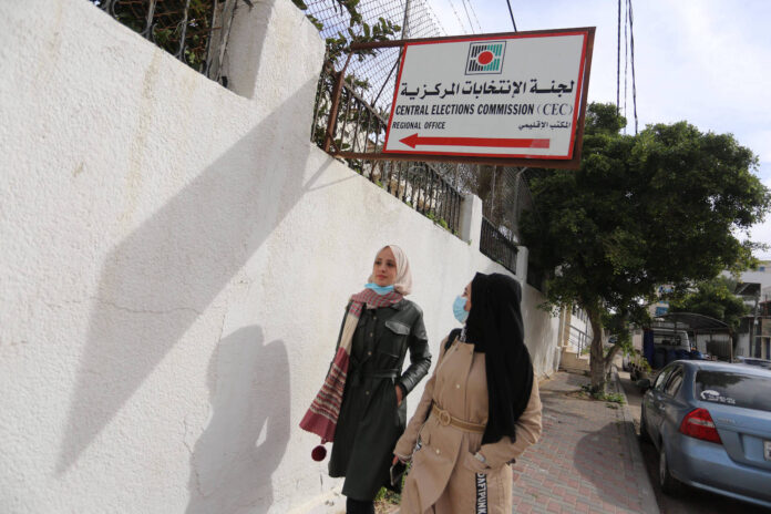 Palästinenserinnen passieren das Hauptquartier der Zentralen Wahlkommission (CEC) in Gaza-Stadt am 17. Januar 2021. Foto IMAGO / ZUMA Wire