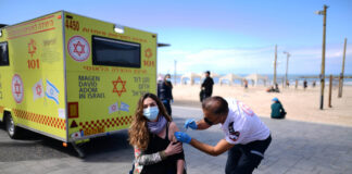 Eine israelische Frau wird in einer temporären Einrichtung des israelischen Rettungsdienstes Magen David Adom in Tel Aviv gegen COVID-19 geimpft. Foto IMAGO / Xinhua