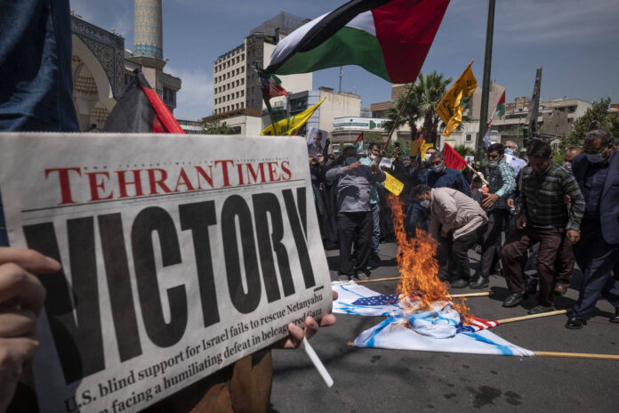 Als Reaktion auf die Waffenruhe zwischen Israel und den Palästinensern verbrennen iranische Demonstranten im Iran die Flaggen der USA und Israels auf dem Palästina-Platz im Zentrum von Teheran, am 22. Mai 2021. Foto IMAGO / NurPhoto