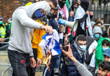 22. Mai 2021: Demonstranten setzen eine israelische Flagge in Brand, als sie sich in der Nähe der israelischen Botschaft in Kensington, im Zentrum Londons versammeln. Unter den teilnehmenden Gruppen waren Sektionen der National Education Gewerkschaft, die Palestine Solidarity Campaign, Palestine Action und Stop The War Coalition. Foto IMAGO / VXPictures.com