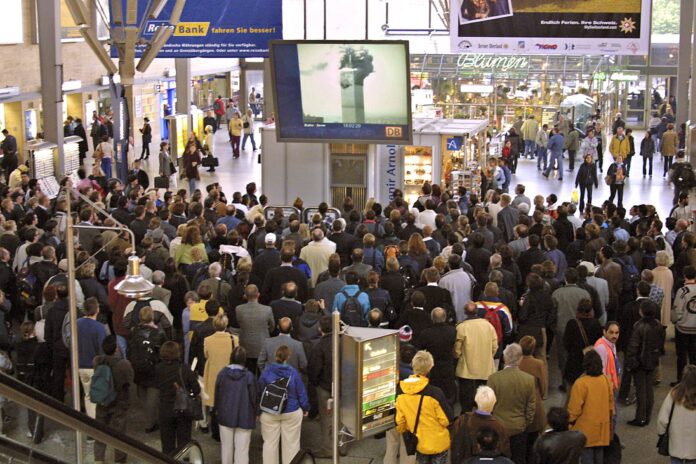 Münchner verfolgen auf einem Bildschirm am Hauptbahnhof eine Fernsehübertragung der Terroranschläge vom 11. September 2001 n New York. Foto IMAGO / HRSchulz