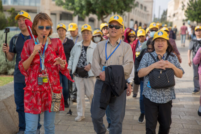 Touristen schlendern mit ihrer Reiseleiterin durch die Strassen von Jerusalem. Foto Yehonatan Valtser/TPS