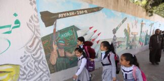 Palästinensische Schüler passieren am 11. Dezember 2021 in Khan Younis im südlichen Gazastreifen ein Wandgemälde zum 34. Jahrestag der Gründung der Terrororganisation Hamas. Foto IMAGO / ZUMA Wire