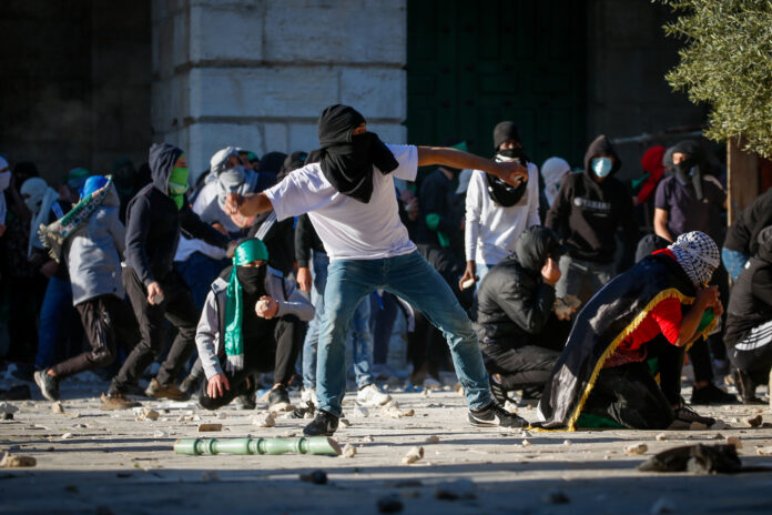 Palästinensische Randalierer bewerfen israelische Sicherheitskräfte auf dem Gelände der Al-Aqsa-Moschee auf dem Tempelberg in der Jerusalemer Altstadt mit Steinen, am 15. April 2022. Foto Jamal Awad/Flash90