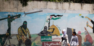 Palästinenser gehen am 29. Mai 2022 in Khan Younis, im südlichen Gazastreifen an einem Wandgemälde vorbei, das Terroristen zeigt, die Raketen auf Israel abfeuern. Foto IMAGO / UPI Photo