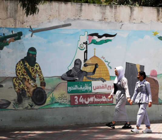 Palästinenser gehen am 29. Mai 2022 in Khan Younis, im südlichen Gazastreifen an einem Wandgemälde vorbei, das Terroristen zeigt, die Raketen auf Israel abfeuern. Foto IMAGO / UPI Photo