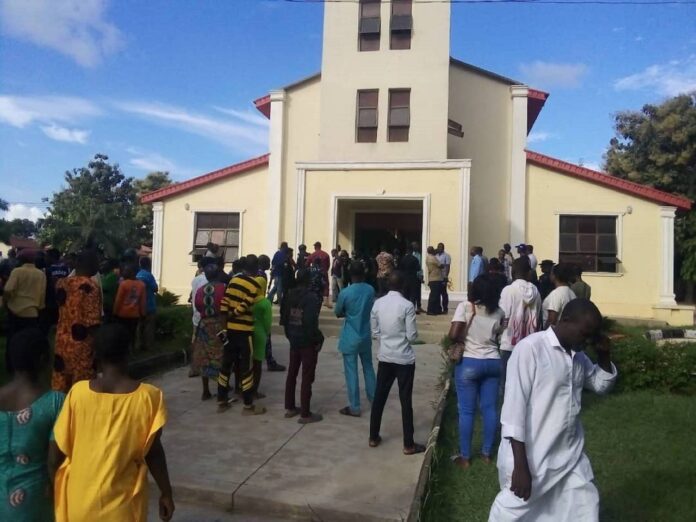 Menschen versammeln sich vor der Kirche, die von bislang nicht identifizierten Bewaffneten in der Stadt Owo im nigerianischen Bundesstaat Ondo angegriffen wurde, 5. Juni 2022. Foto IMAGO / Xinhua