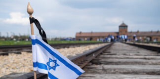 Eine israelische Flagge auf den Bahngleisen im Konzentrationslager Birkenau. Foto IMAGO / ZUMA Wire