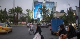 Iranische Frauen passieren am 7. Juni 2023 auf dem "Palästina-Platz" in der Innenstadt von Teheran ein riesiges Bild der Fattah, der ersten iranischen Hyperschallrakete. Foto IMAGO / NurPhoto