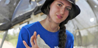 Aviv Weizman hält die "Zauberspiegel"-Scherbe, die sie in Usha entdeckt hat. Foto Emil Aladjem / Israel Antiquities Authority