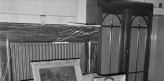 US-Hauptmann H. H. Davies prüft eine Gemäldesammlung, die im Haus eines SS-Angehörigen in Hannover gefunden wurde, der sie aus Holland geraubt hatte. Foto BU 9651 aus den Sammlungen der Imperial War Museums, Public Domain, https://commons.wikimedia.org/w/index.php?curid=24494576