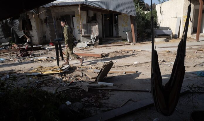 Eine israelische Soldatin durchschreitet die Zerstörung in der Gemeinde Kfar Azza. Foto IMAGO / UPI Photo