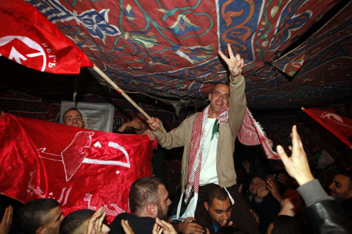 Salah Hamouri (mit PFLP Fahne und Victory Zeichen) wird nach seiner Entlassung aus israelischer Haft im Rahmen eines Gefangenenaustauschs mit der Hamas in seinem Haus in Jerusalem gefeiert, 18. Dezember 2011. Foto Sliman Khader/FLASH90