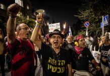Während einer Demonstration schwenken Demonstranten ein Plakat mit der hebräischen Aufschrift "Wunderbares Volk - Scheiss Regierung". Jerusalem, 02.04.2024. Foto IMAGO / ZUMA Wire