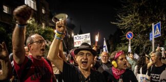 Während einer Demonstration schwenken Demonstranten ein Plakat mit der hebräischen Aufschrift "Wunderbares Volk - Scheiss Regierung". Jerusalem, 02.04.2024. Foto IMAGO / ZUMA Wire