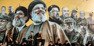 Hisbollah-Anhänger sitzen vor einem Plakat getöteter Parteiführer in Beirut am 26. Juni 2026. Foto IMAGO / ZUMA Press